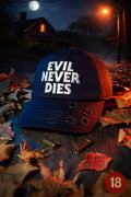 "Navy blue distressed horror dad cap with white ‘Evil Never Dies’ embroidery and bullet hole details, photographed on halloween night on a leafy 1970s suburban street."