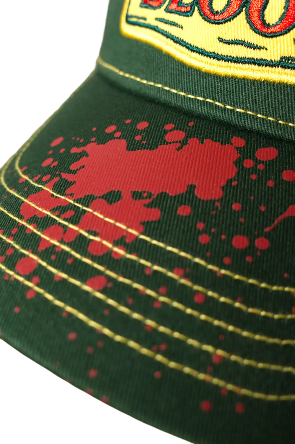 Close-up of red blood splatter screen print on the brim of a green horror baseball cap