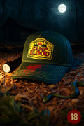 Green horror baseball cap with embroidered ‘Camp Blood’ patch and blood-splattered peak, photographed at night in a 1980s lakeside forest setting.
