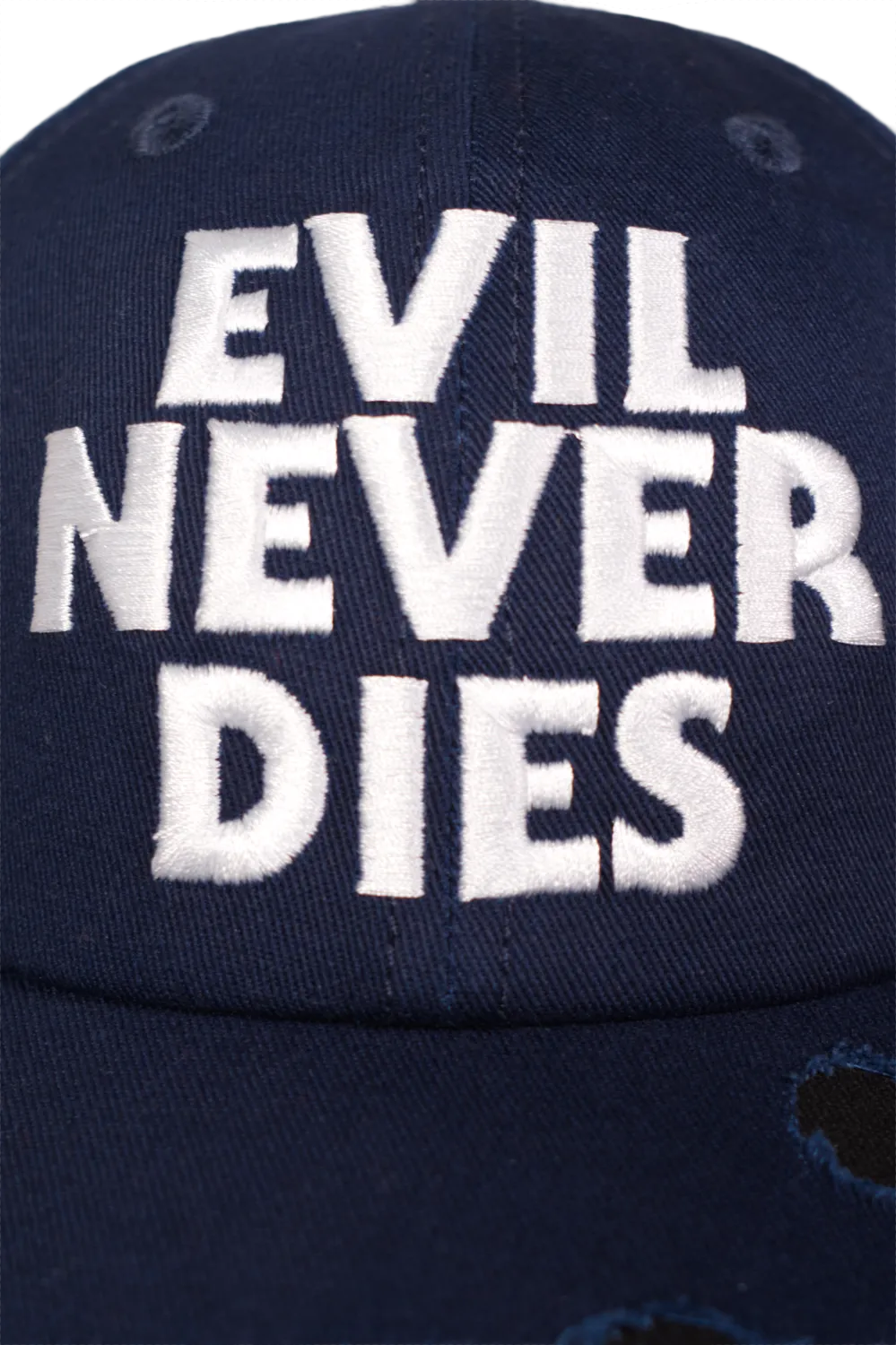 Close-up of white embroidered “Evil Never Dies” text on navy horror baseball cap, inspired by Halloween