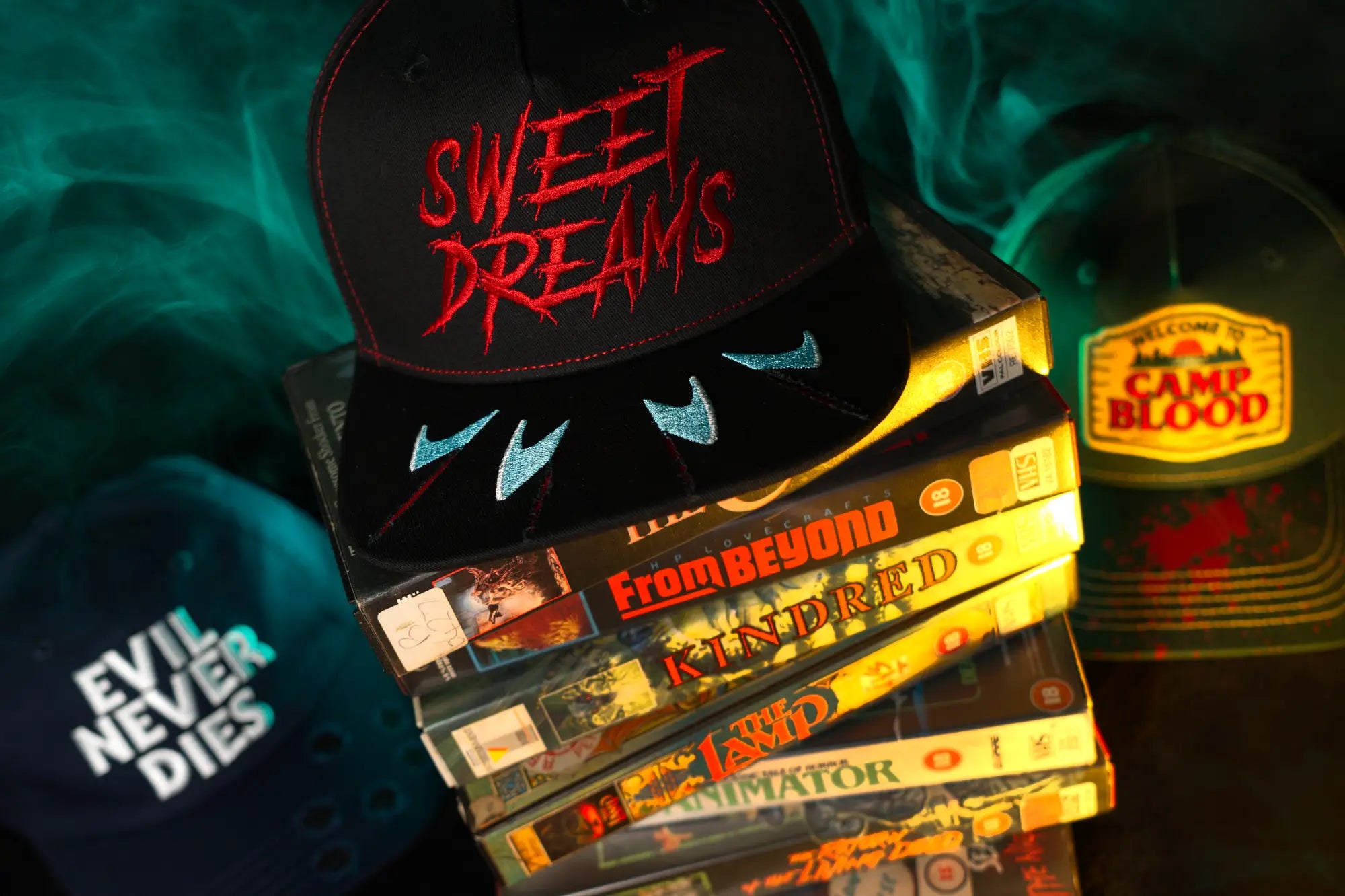 Sweet Dreams horror cap, inspired by nightmare on elm street. Displayed on stacked VHS tapes, part of the Splatter Caps VHS-inspired slasher headwear collection.